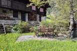 Nestled in a serene landscape, this charming stone and wood chalet boasts a delightful outdoor dining area.