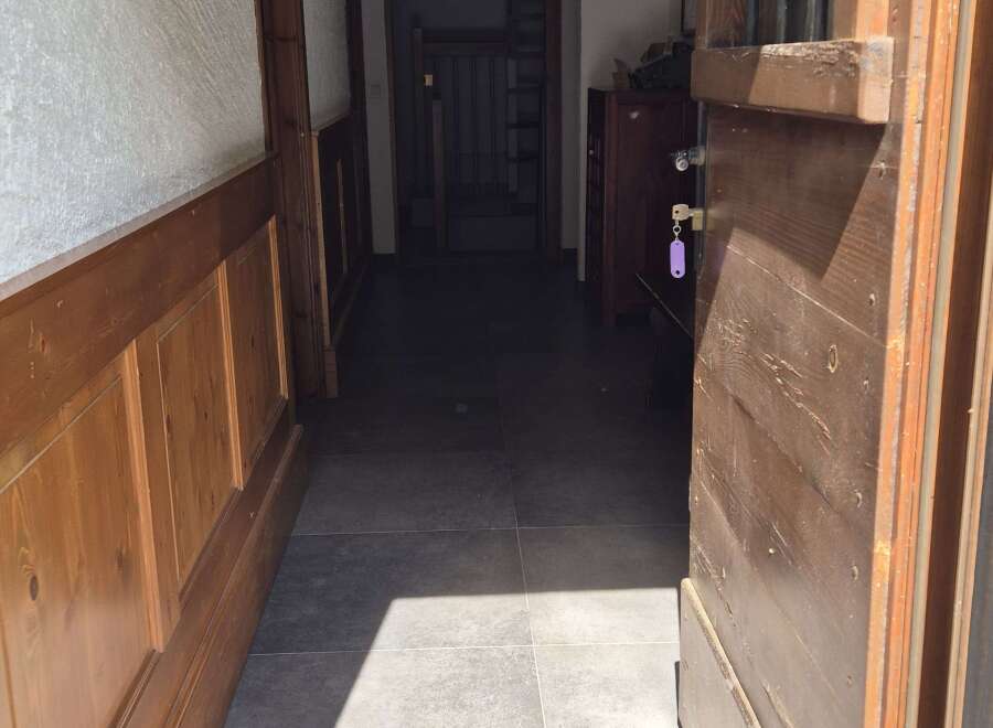 Step inside this inviting property, where a rustic wooden door opens to a charming hallway.