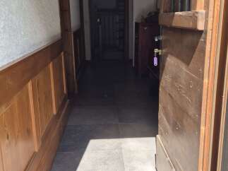 Step inside this inviting property, where a rustic wooden door opens to a charming hallway.