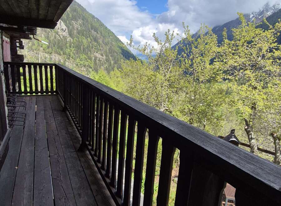 Escape to tranquility with this stunning property featuring a spacious balcony overlooking lush greenery and majestic mountains.