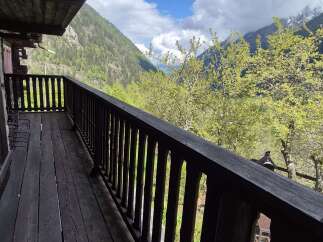Escape to tranquility with this stunning property featuring a spacious balcony overlooking lush greenery and majestic mountains.