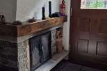 This cozy home features a stone fireplace with a wooden mantel, perfect for creating a warm and inviting atmosphere.