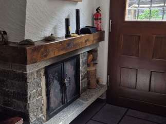 This cozy home features a stone fireplace with a wooden mantel, perfect for creating a warm and inviting atmosphere.