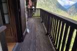 Charming balcony with wooden floor and railing offering stunning mountain views.