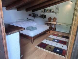 Discover the charm of this attic bedroom featuring exposed wooden beams, adding rustic appeal to the space.