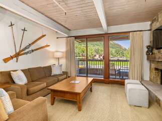 This inviting living room boasts a cozy seating area with a comfortable brown sofa, complemented by unique ski-themed decor.