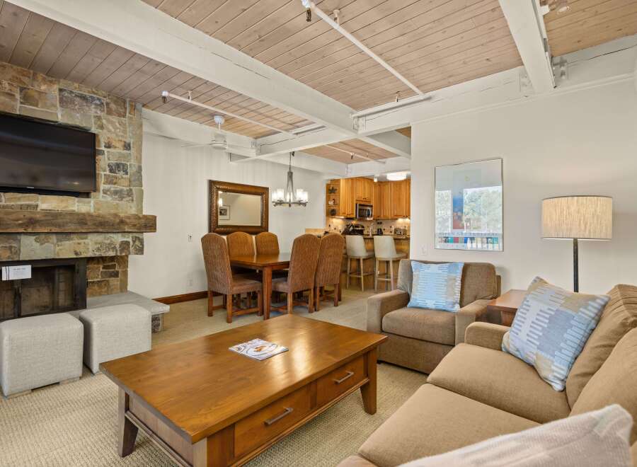 This inviting living space features a stone fireplace with a mounted TV, perfect for cozy evenings.