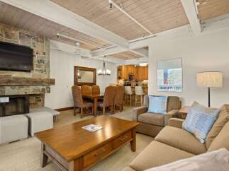 This inviting living space features a stone fireplace with a mounted TV, perfect for cozy evenings.