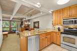 Step inside this inviting kitchen featuring warm wood cabinetry, granite countertops, and stainless steel appliances, perfect for culinary enthusiasts.