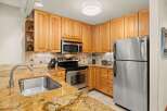 This well-maintained kitchen features warm wood cabinetry, stainless steel appliances, and stunning granite countertops, providing both style and functionality.