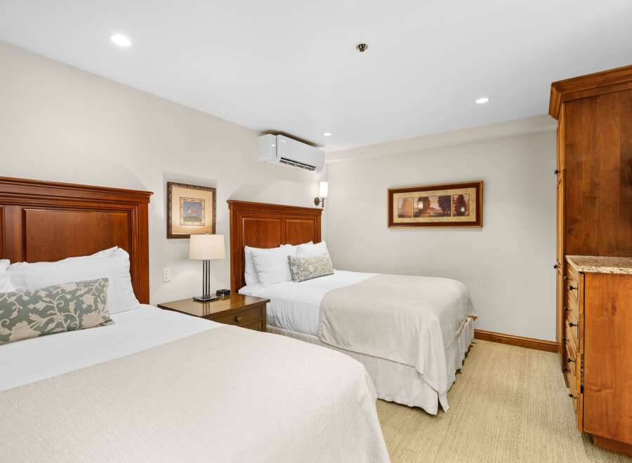 This inviting bedroom features two twin beds with plush bedding and decorative pillows, promising a restful night's sleep.