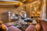 Luxury chalet interior featuring a cozy living area with a modern fireplace, plush seating, and rustic wooden beams, perfect for a ski vacation.