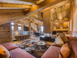 Luxury chalet interior featuring a cozy living area with a modern fireplace, plush seating, and rustic wooden beams, perfect for a ski vacation.