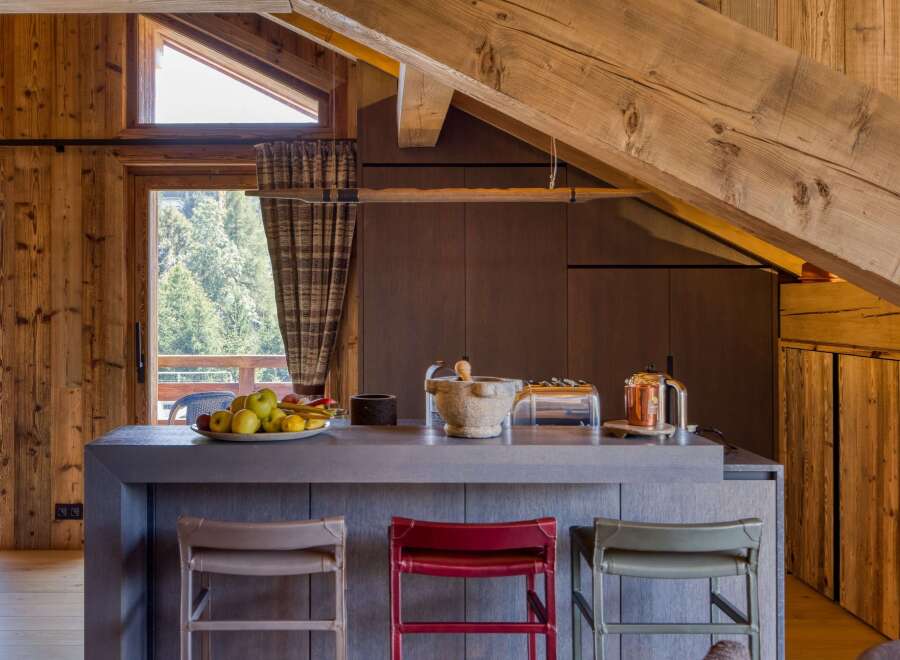 This stunning chalet-style kitchen features warm wood accents and modern gray countertops, creating a cozy yet sophisticated atmosphere.