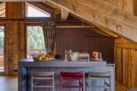 This stunning chalet-style kitchen features warm wood accents and modern gray countertops, creating a cozy yet sophisticated atmosphere.
