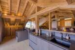 Discover a stunning chalet kitchen with exposed wooden beams, offering a rustic yet modern ambiance.