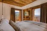Experience luxury living in this chalet-style bedroom with stunning mountain views.