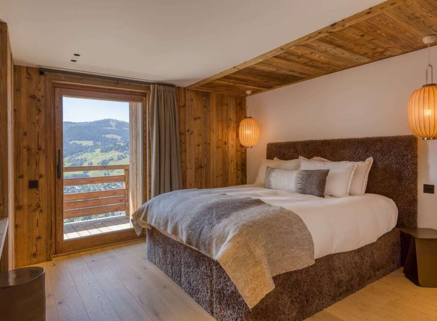 Experience luxury in this mountain view bedroom featuring warm wood accents and modern lighting.