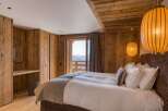 Experience luxurious mountain living in this bedroom with rustic wood finishes and stunning mountain views.