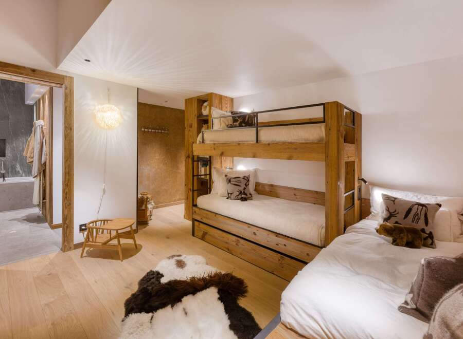 This cozy bedroom features a unique bunk bed design, maximizing space while adding rustic charm.