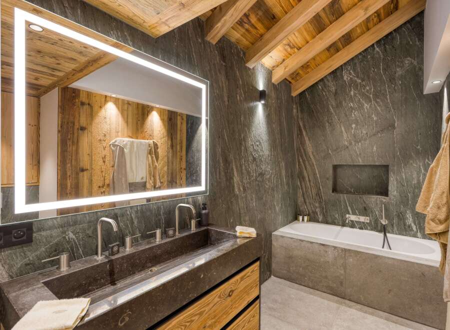 This stunning bathroom showcases rustic charm with its wooden ceiling beams and accent wall, creating a warm and inviting atmosphere.