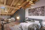 This cozy attic bedroom offers a blend of rustic charm and modern elegance.