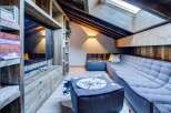 Discover this cozy attic space, featuring a custom wood entertainment center with built-in shelving and storage.