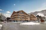Discover luxury living in this stunning wooden chalet-style apartment building, perfectly situated in a picturesque snowy mountain town.