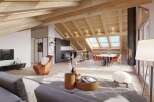 A modern living space with exposed wood beams and skylights offers a bright and airy atmosphere.