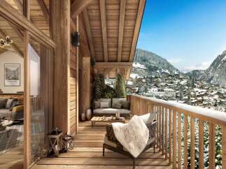 A luxurious chalet balcony offers stunning mountain views, inviting seating, and rustic wooden architecture.