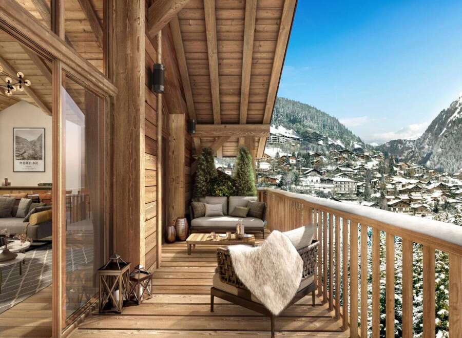A luxurious chalet balcony offers stunning mountain views, inviting seating, and rustic wooden architecture.