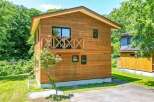 This beautiful two-story house features a natural wood exterior and a charming balcony.