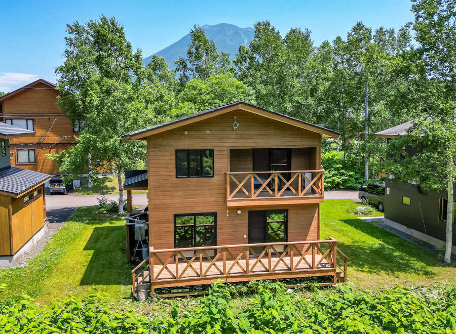 This beautiful two-story house boasts a charming wooden exterior and inviting balconies.