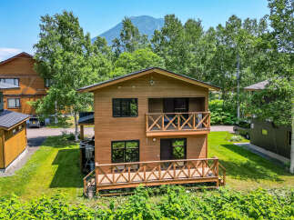 This beautiful two-story house boasts a charming wooden exterior and inviting balconies.