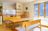This inviting dining area features a wooden table with bench seating, perfect for family meals or entertaining guests.