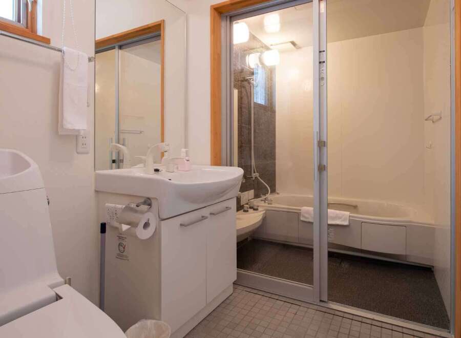 This bathroom features a modern design with a combined toilet and sink area for space efficiency.