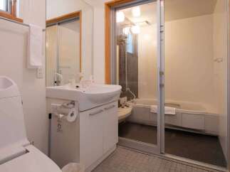 This bathroom features a modern design with a combined toilet and sink area for space efficiency.