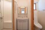 This bathroom features a modern sink with storage, a mirrored medicine cabinet, and a toilet.