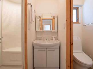 This bathroom features a modern sink with storage, a mirrored medicine cabinet, and a toilet.