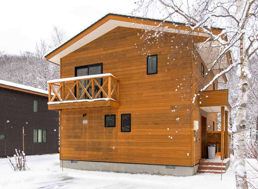 This charming wooden chalet is nestled in a snowy landscape, perfect for a winter getaway.