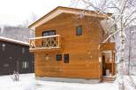 This charming wooden chalet is nestled in a snowy landscape, perfect for a winter getaway.