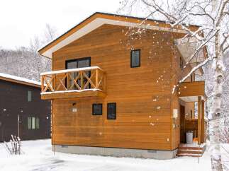 This charming wooden chalet is nestled in a snowy landscape, perfect for a winter getaway.