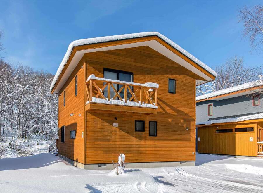 Discover this charming wooden house nestled in a serene, snow-covered landscape.