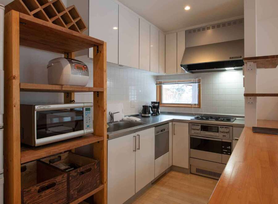 This cozy kitchen is equipped with modern appliances, including a microwave, stove, and refrigerator, making meal preparation a breeze.