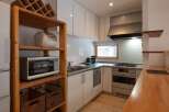 This cozy kitchen is equipped with modern appliances, including a microwave, stove, and refrigerator, making meal preparation a breeze.