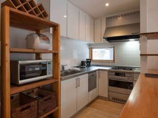 This cozy kitchen is equipped with modern appliances, including a microwave, stove, and refrigerator, making meal preparation a breeze.