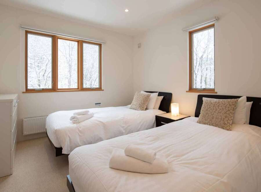 This bedroom features two twin beds with crisp white linens, perfect for a vacation rental or guest room.