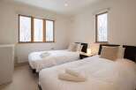 This bedroom features two twin beds with crisp white linens, perfect for a vacation rental or guest room.