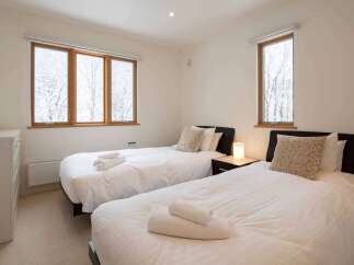 This bedroom features two twin beds with crisp white linens, perfect for a vacation rental or guest room.