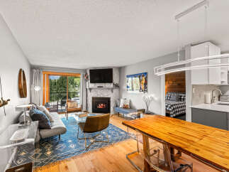 This inviting living space boasts a stone fireplace and a flat-screen TV, perfect for cozy evenings.